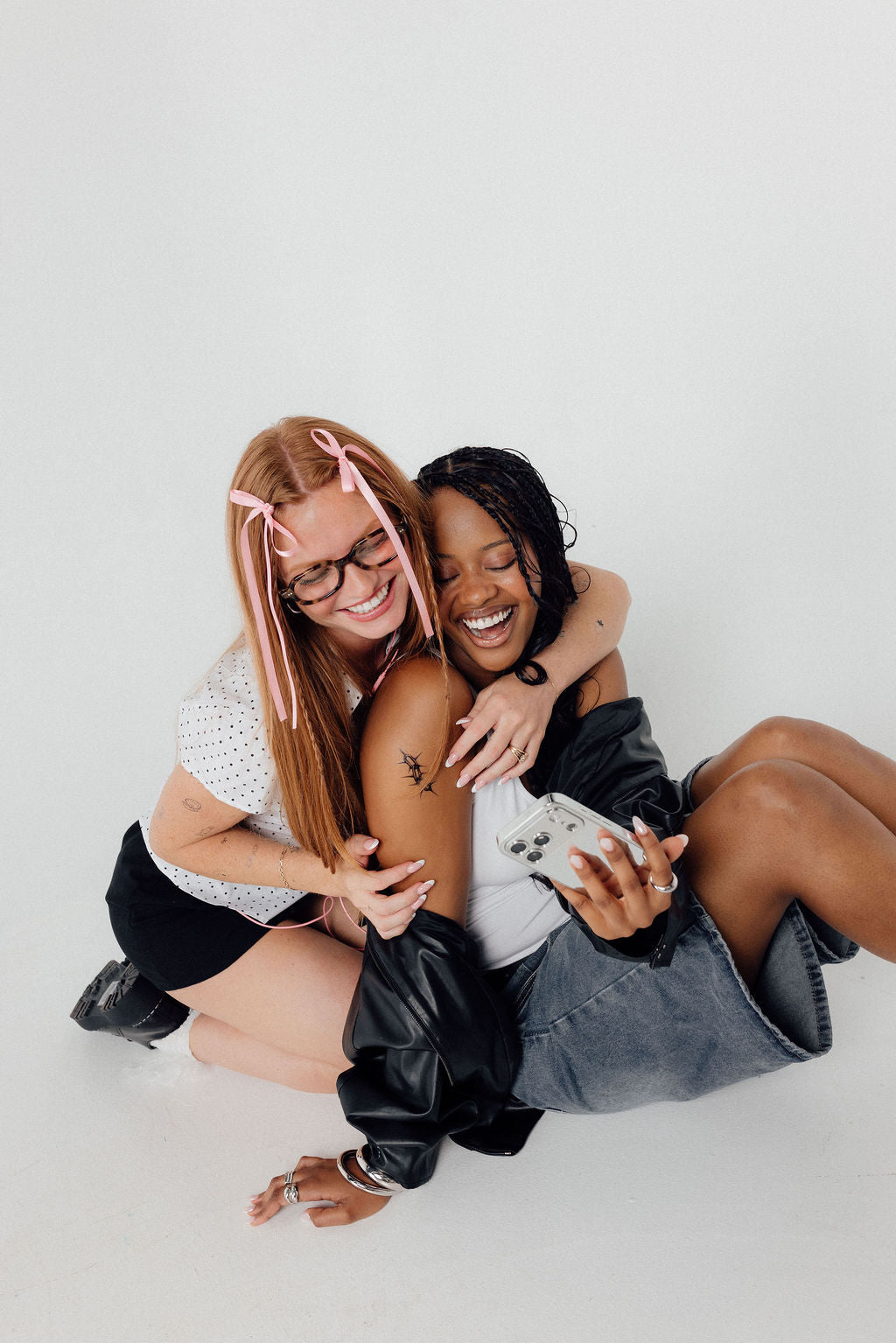 Two friends hugging and laughing together after their tattoo appointments